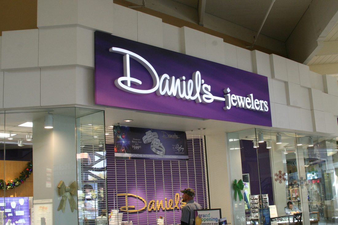 Illuminated channel letter sign glowing on a Fresno, CA storefront at dusk