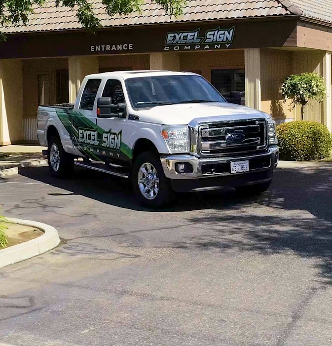 Excel Sign Company storefront with branded trucks in Clovis, CA